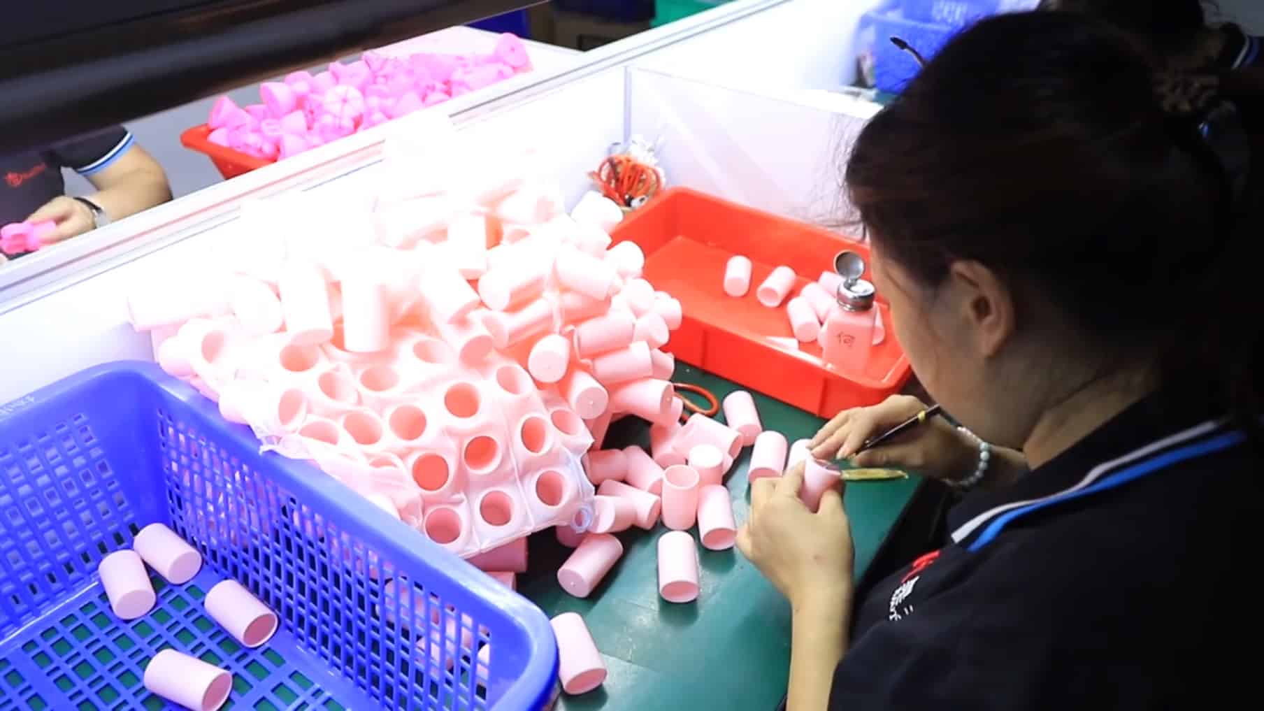 Worker assembling and inspecting custom silicone parts in a clean manufacturing environment