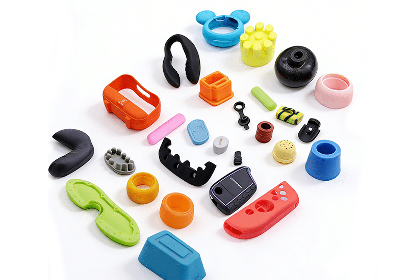 Assorted colorful silicone components showing various shapes and sizes, demonstrating custom silicone parts for consumer electronics and toys