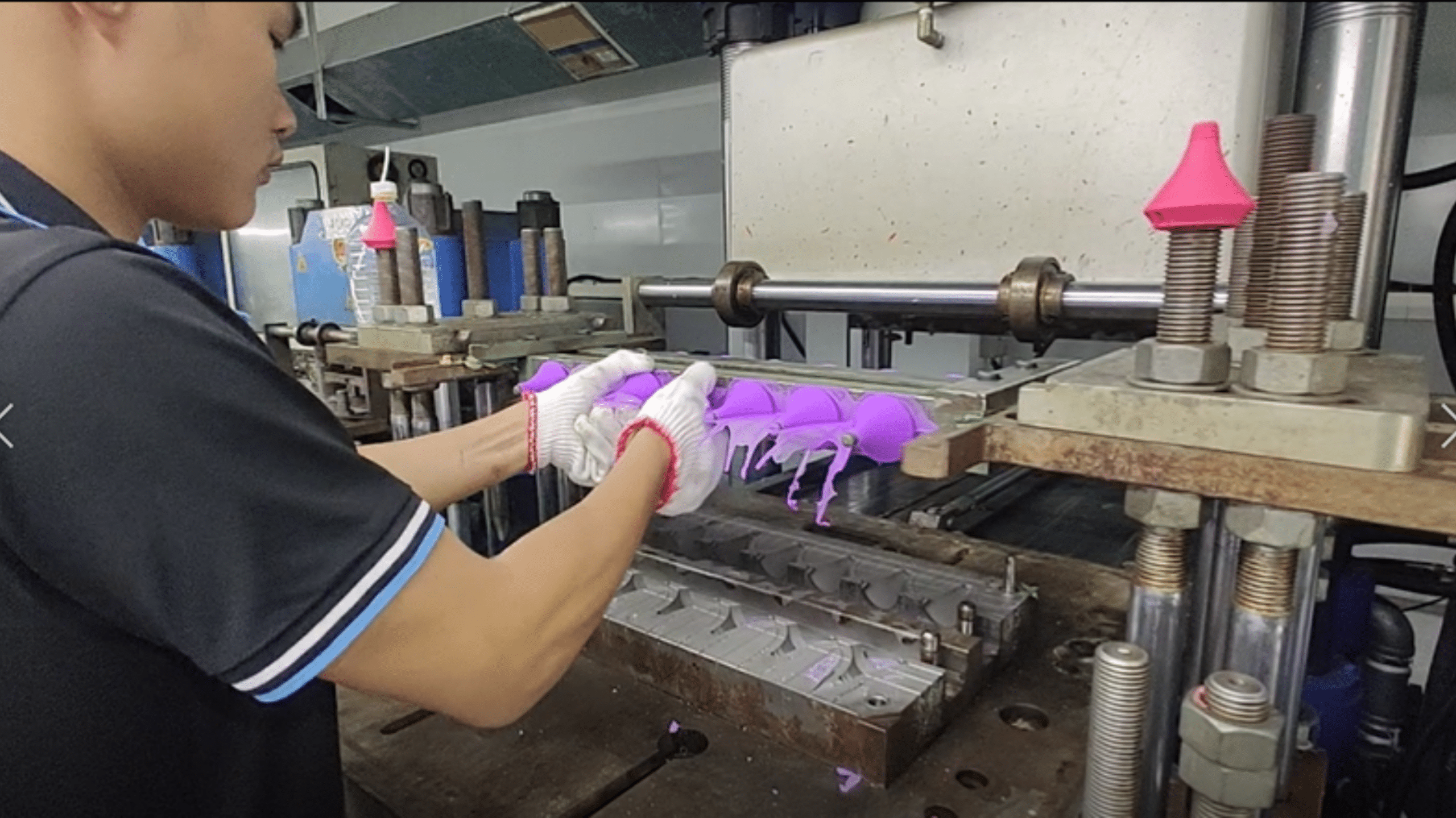 Factory workers assembling silicone sheets on production line"