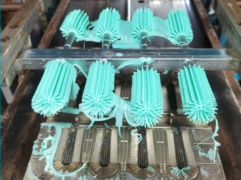 Freshly molded silicone brush heads on a multi cavity mold runner inside the production tooling