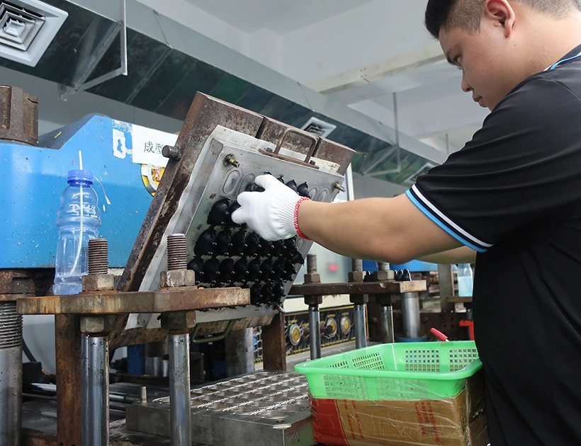 Silicone compression molding process with worker removing molded rubber parts from industrial mold